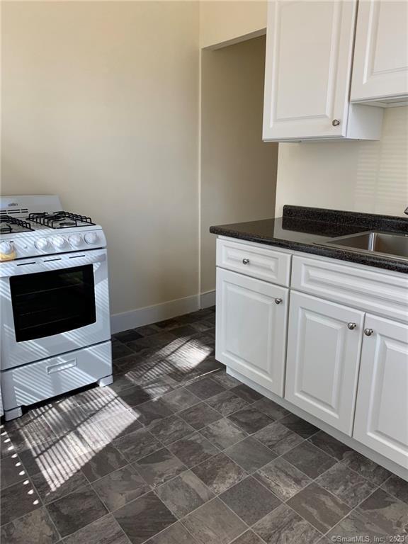 198 Flax Hill Road, Unit 3 Norwalk, CT 06854 - Photo 9 of 12 a kitchen with granite countertop a stove and a sink