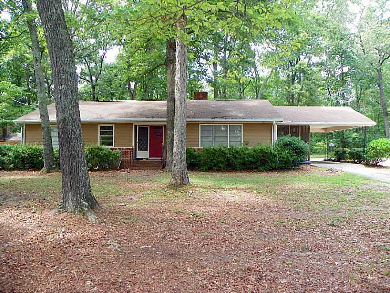 a view of a house with backyard and a tree