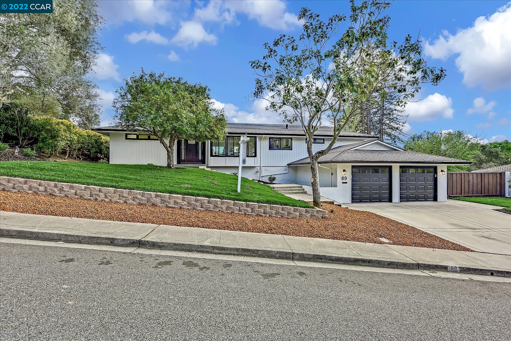 a front view of a house with a garden and trees