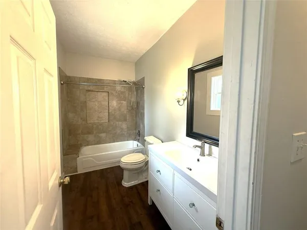 a bathroom with a double vanity sink toilet mirror and bathtub