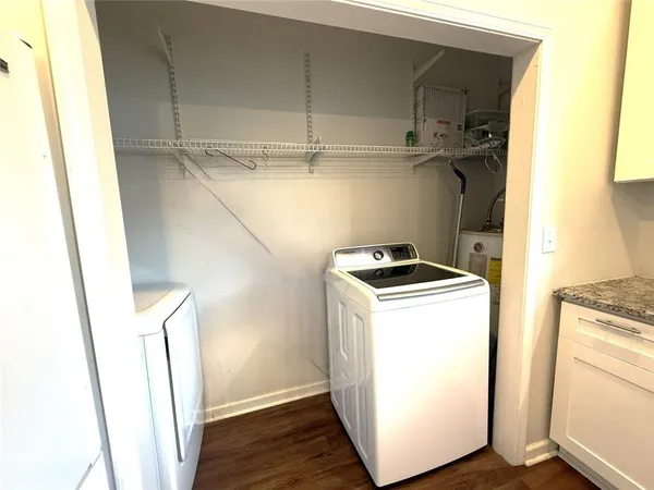 a utility room with wooden floor washer and dryer