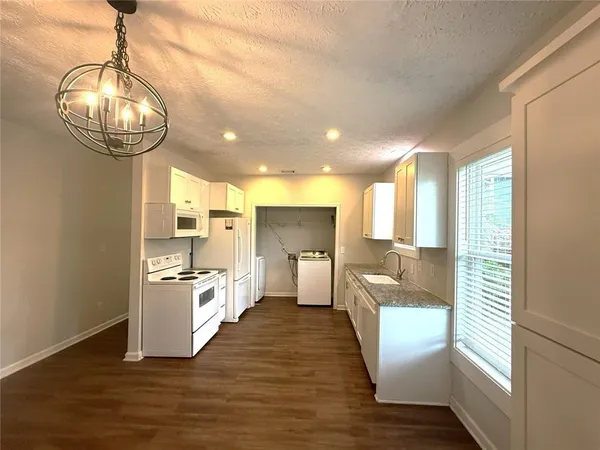 a kitchen with kitchen island white cabinets and stainless steel appliances