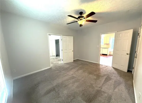 a view of a big room with wooden floor and windows