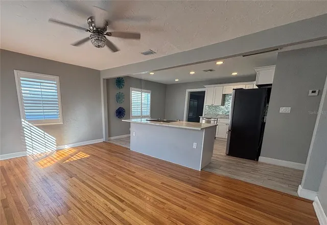 a view of kitchen with sink and refrigerator