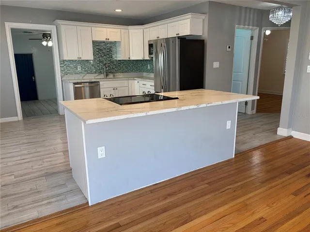 a large kitchen with stainless steel appliances a refrigerator and a stove top oven