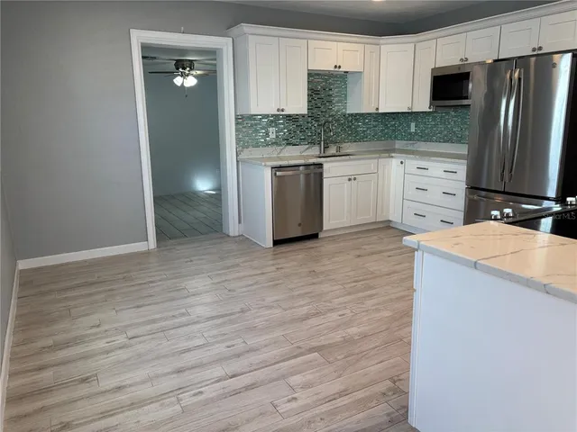 a kitchen with stainless steel appliances granite countertop a refrigerator and a stove top oven