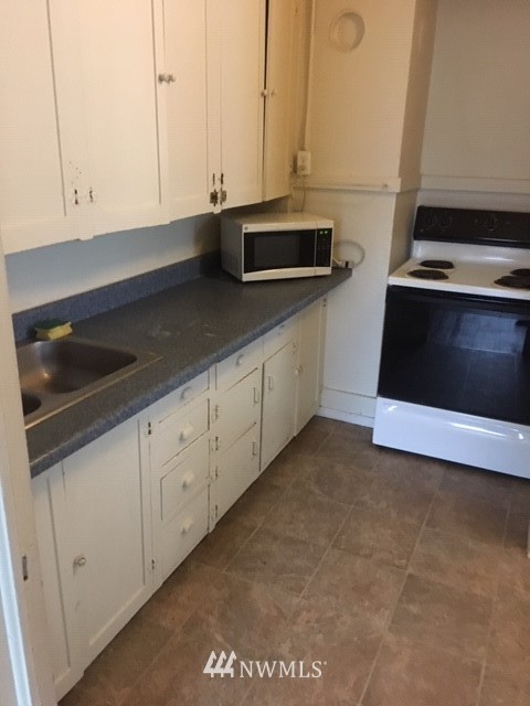 421 South Mission Street Wenatchee, WA 98801 - Photo 6 of 7 a kitchen with granite countertop white cabinets and stainless steel appliances