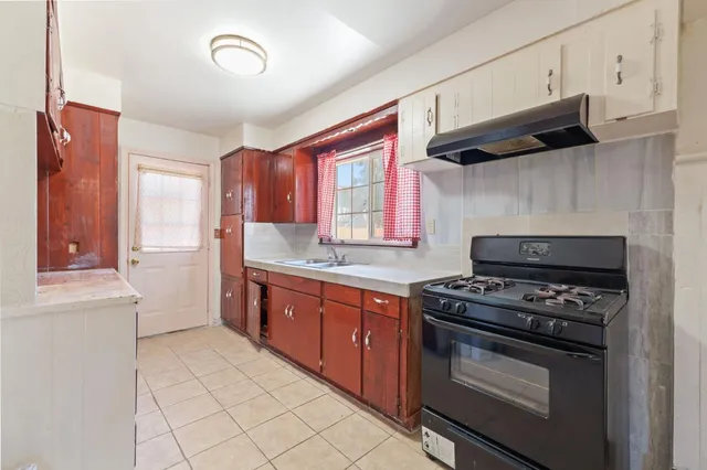 a kitchen with stainless steel appliances a stove a sink and a refrigerator