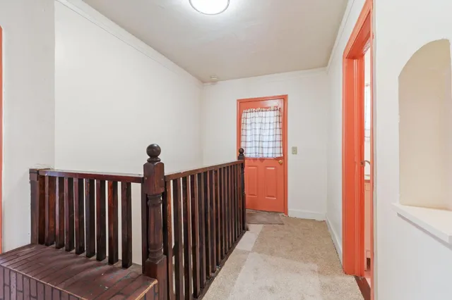 a view of a hallway with wooden floor and stairs