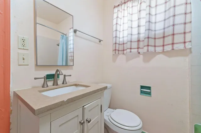 a bathroom with a sink vanity mirror and toilet