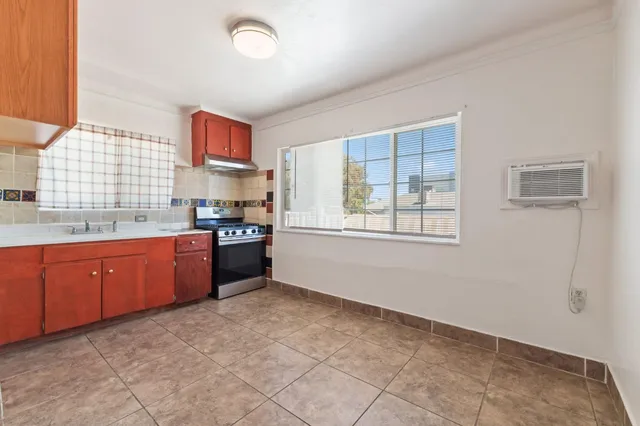 a kitchen with granite countertop a stove cabinets and a sink