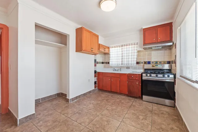 a large kitchen with stainless steel appliances granite countertop a stove a sink and a refrigerator