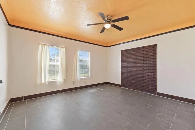 an empty room with windows and fan