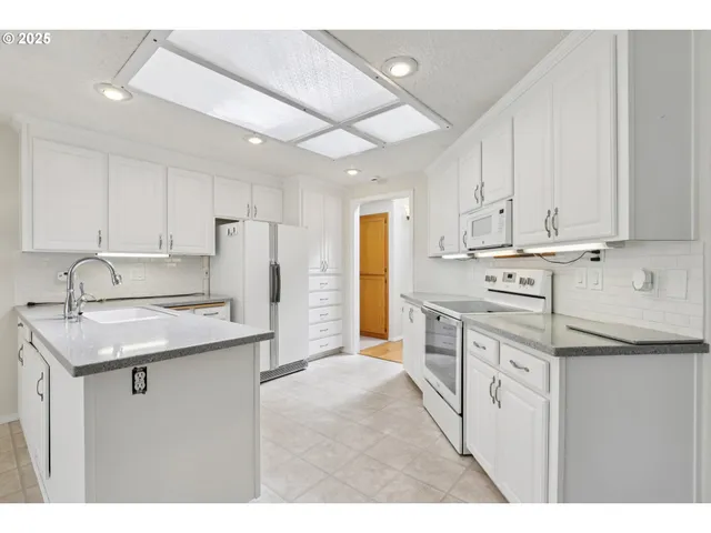 a kitchen with kitchen island a sink stainless steel appliances and cabinets
