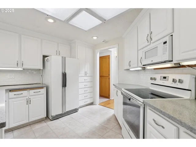 a kitchen with stainless steel appliances granite countertop a refrigerator and a stove
