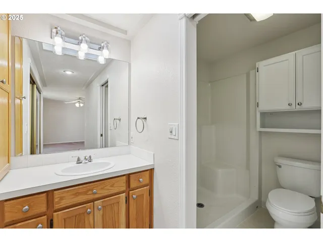 a bathroom with a granite countertop sink toilet and shower