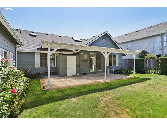 a big house with a big yard and potted plants in front of it