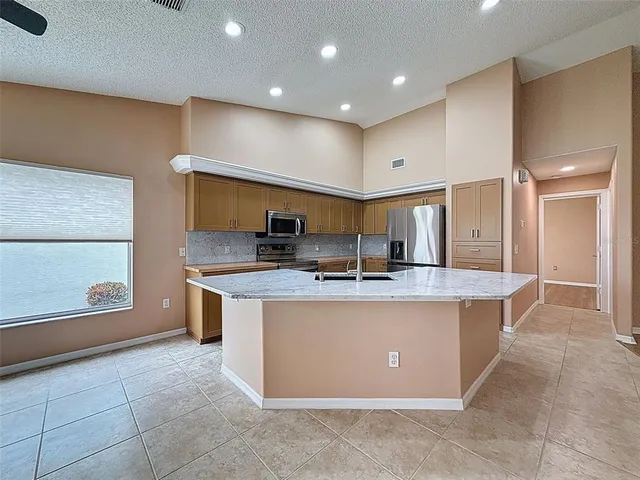 a view of an empty room with chandelier fan and a window