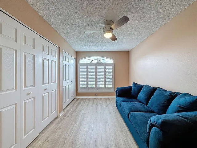 a view of an empty room with wooden floor and closet area