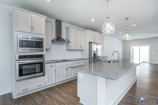 a kitchen with stainless steel appliances granite countertop a stove oven and a white cabinets