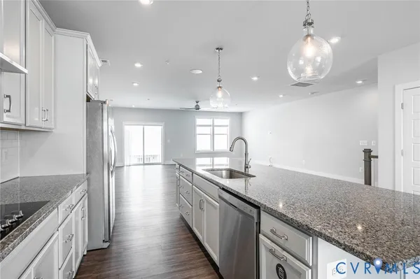 a kitchen with granite countertop kitchen island a sink appliances and cabinets
