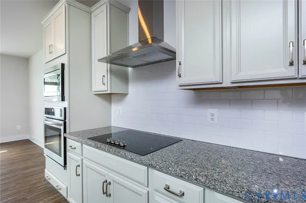 a kitchen with granite countertop a sink stainless steel appliances and cabinets