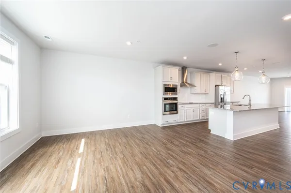 a view of kitchen with wooden floor and electronic appliances