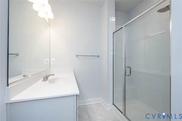 a bathroom with a sink shower and a mirror