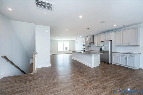 a kitchen with a refrigerator and a stove top oven