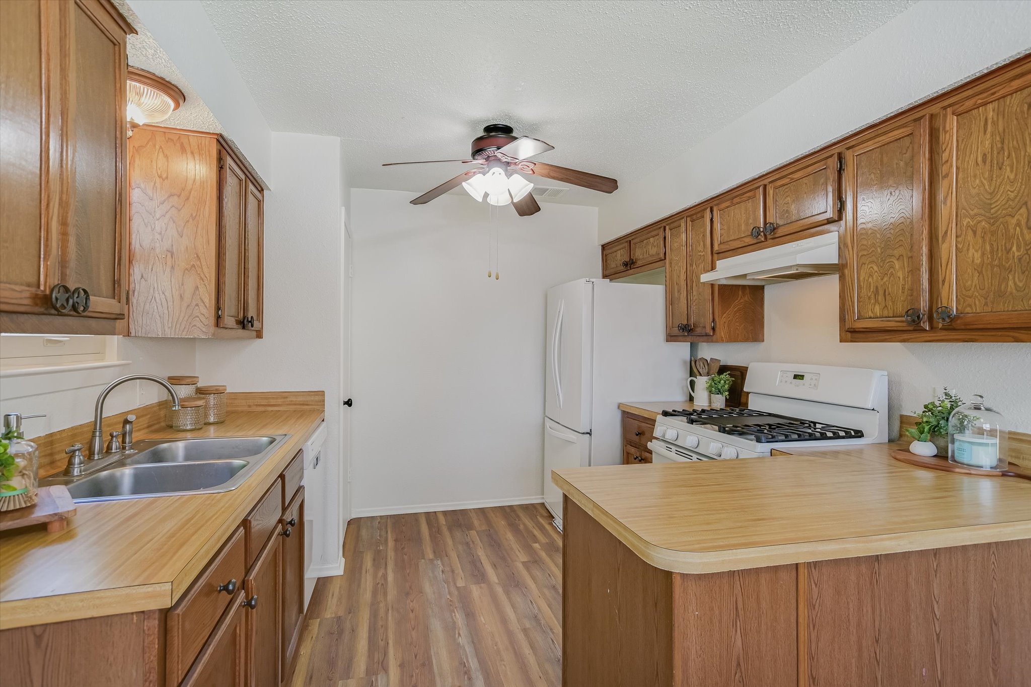 606 Splitrock Round Rock, TX 78681 - Photo 5 of 18 a kitchen with a sink dishwasher a stove and a refrigerator with wooden floor