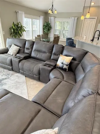 a living room with furniture kitchen view and a chandelier