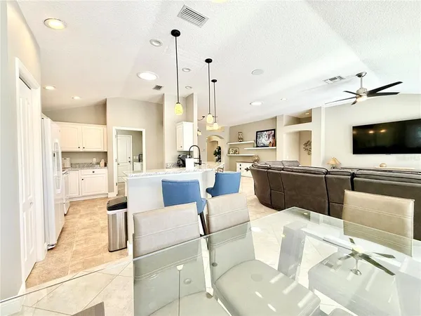 a large kitchen with kitchen island granite countertop a sink and white cabinets