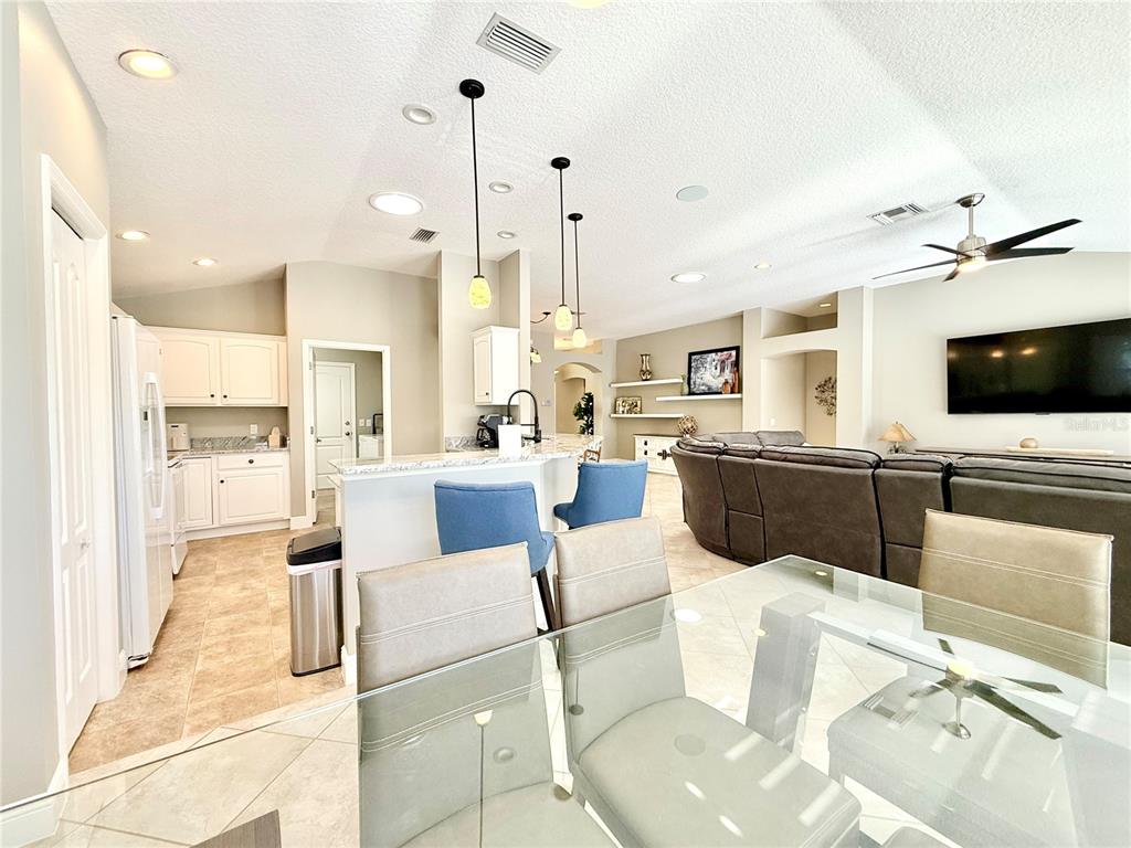 3088 Berwyn Way The Villages, FL 32162 - Photo 15 of 60 a living room with stainless steel appliances kitchen island granite countertop a stove and a view of living room with a flat screen tv