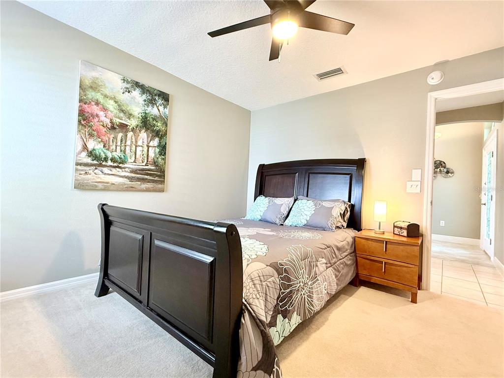 3088 Berwyn Way The Villages, FL 32162 - Photo 6 of 60 a bedroom with a bed and a chandelier