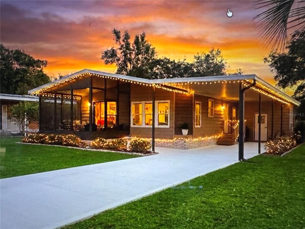a view of a house with a yard and sitting area