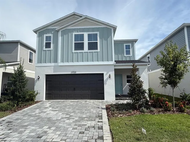 a front view of a house with a garden and garage