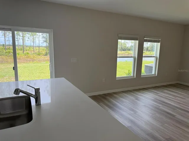 a view of a room with wooden floor and a window
