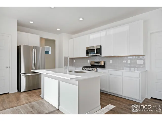 a kitchen with kitchen island a sink stainless steel appliances and cabinets