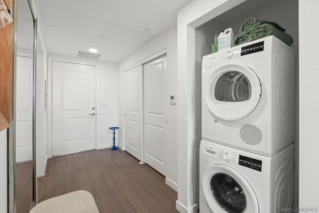 a living room with furniture a washer and dryer with wooden floor