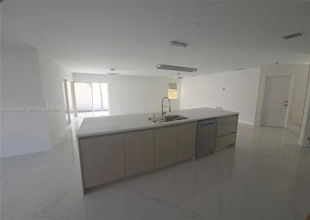 a kitchen with stainless steel appliances a refrigerator sink and white cabinets