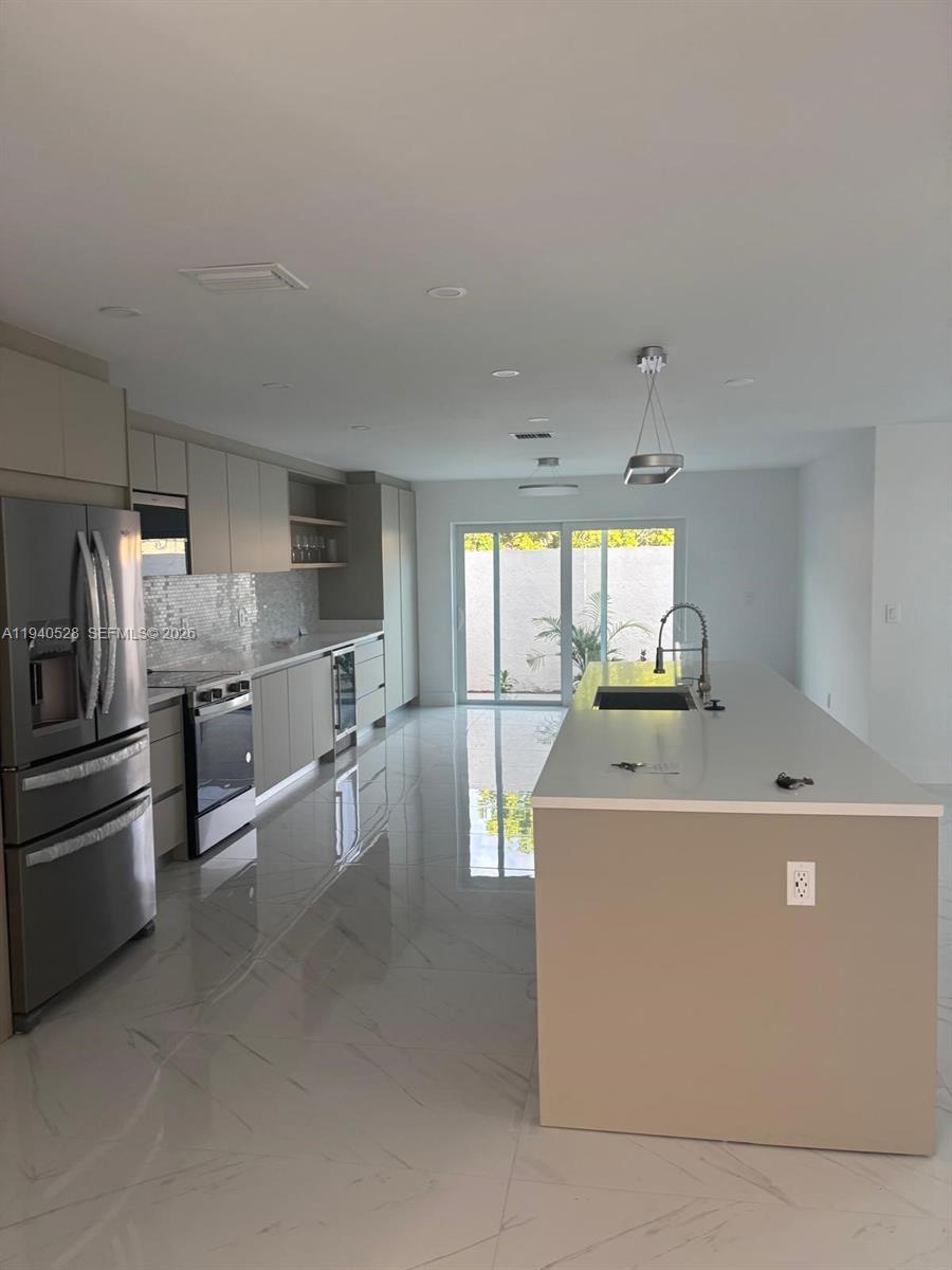13911 Southwest 100th Lane Miami, FL 33186 - Photo 12 of 55 a kitchen with stainless steel appliances a refrigerator sink and white cabinets
