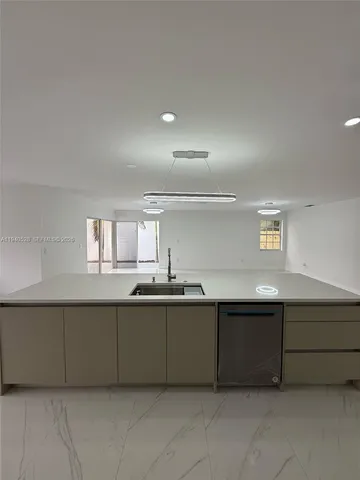 a living room with stainless steel appliances kitchen island a cabinets and a couch