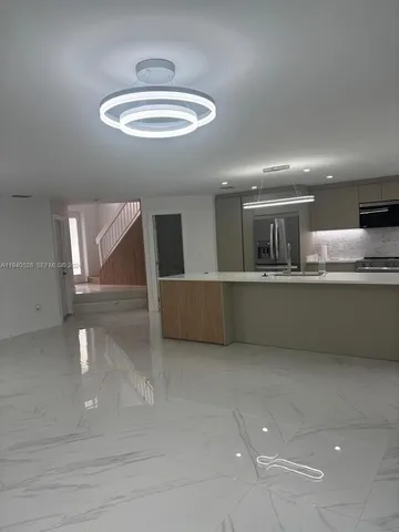 a large kitchen with stainless steel appliances lots of counter space and a sink