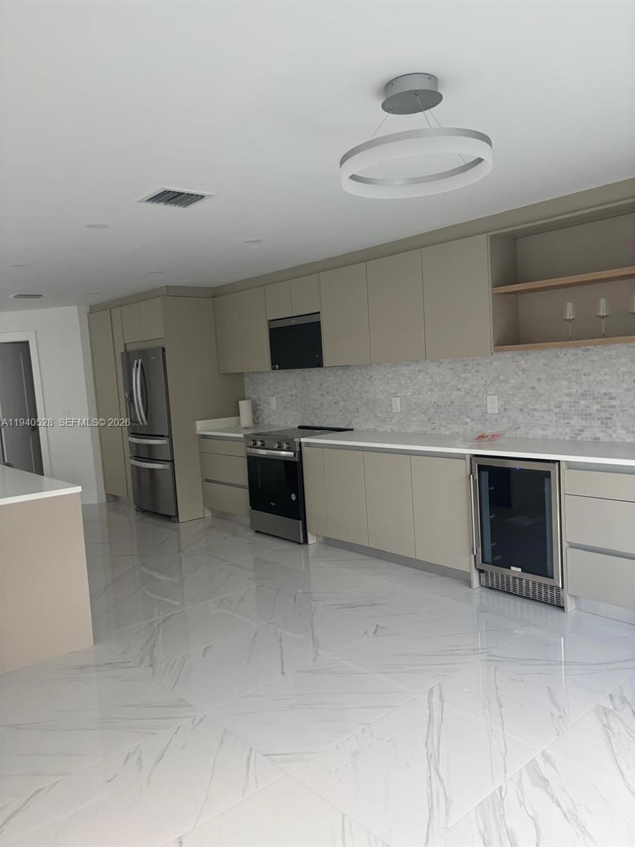 13911 Southwest 100th Lane Miami, FL 33186 - Photo 20 of 55 a kitchen with stainless steel appliances kitchen island a refrigerator sink and cabinets