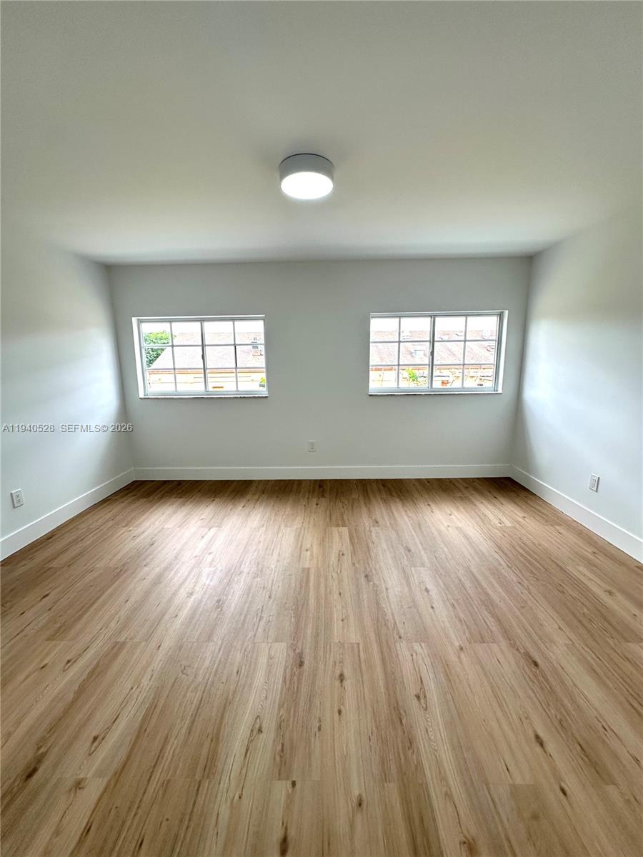 13911 Southwest 100th Lane Miami, FL 33186 - Photo 29 of 55 an empty room with wooden floor and windows
