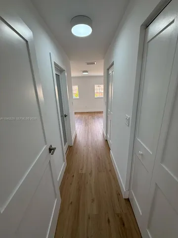 a view of room with wooden floor and white walls
