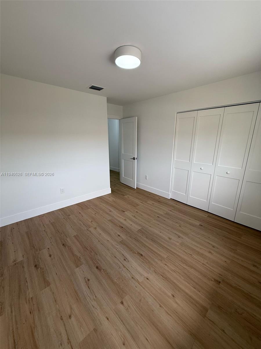 13911 Southwest 100th Lane Miami, FL 33186 - Photo 34 of 55 a view of room with wooden floor and white walls