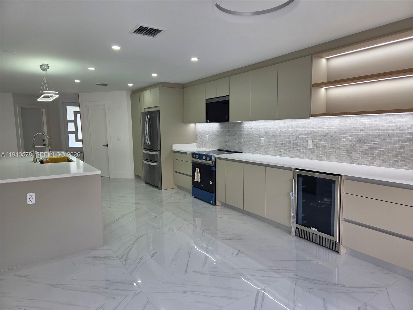 13911 Southwest 100th Lane Miami, FL 33186 - Photo 9 of 55 a large kitchen with stainless steel appliances a large counter top and a stove