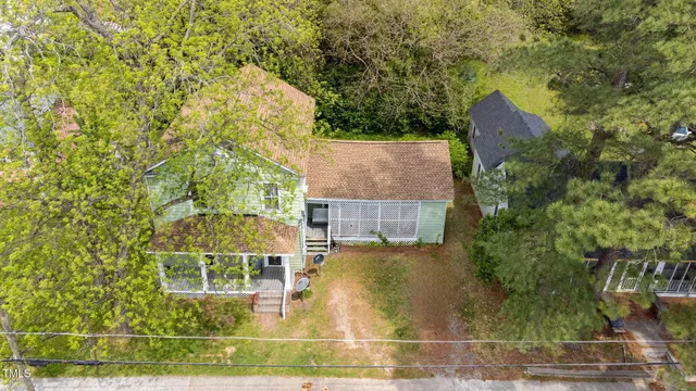 an aerial view of a house with a yard and large trees