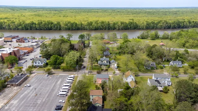 an aerial view of residential houses with outdoor space and trees